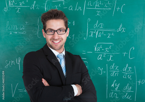 Confident Professor Standing Against Blackboard