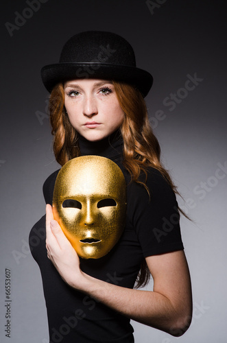 Bild auf Leinwand Redhead woman in hat  iwith mask in hypocrisy consept against gr