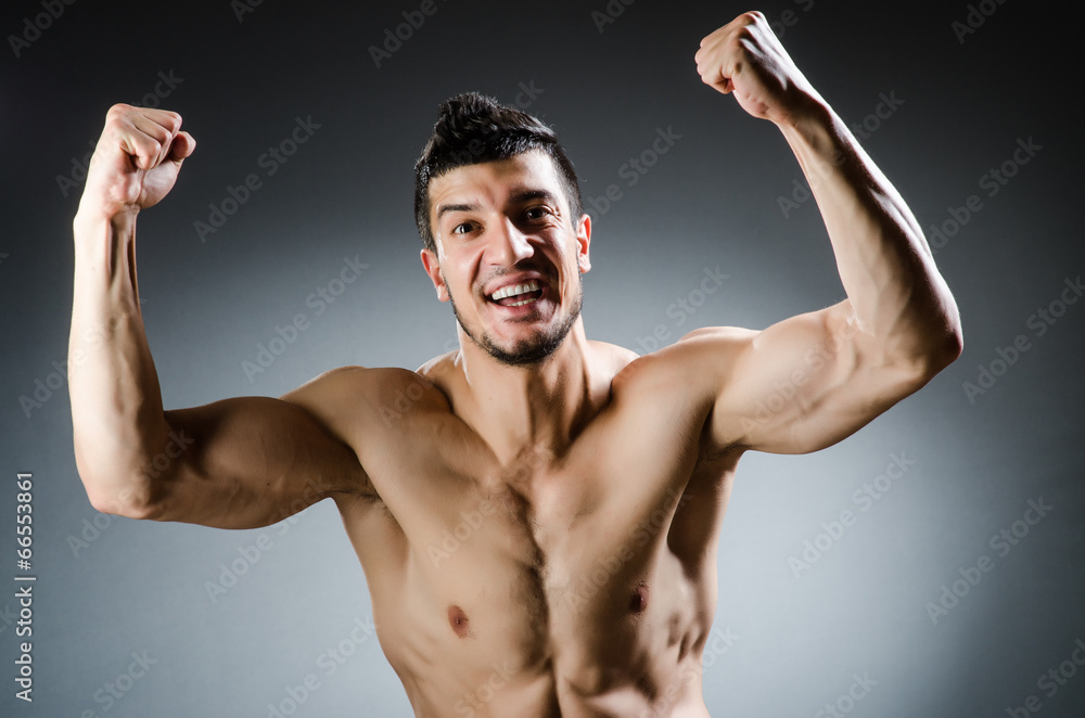 Muscular man posing in dark studio Muscular man posing in dark studio