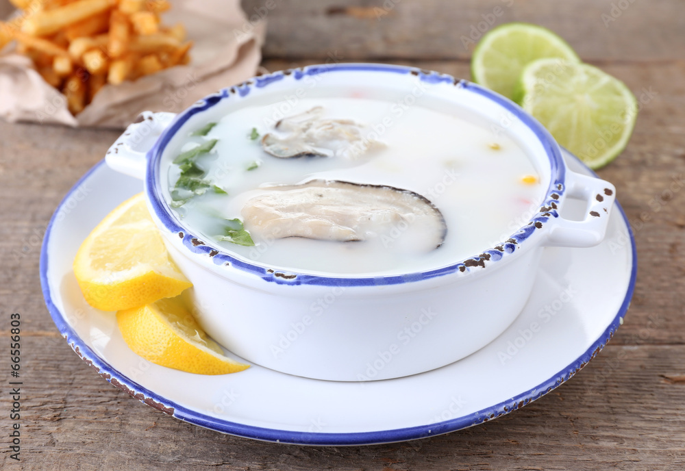 Tasty soup with oysters on wooden table Tasty soup with oysters on wooden table