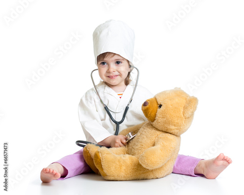 kid girl with clothes of doctor playing with toy