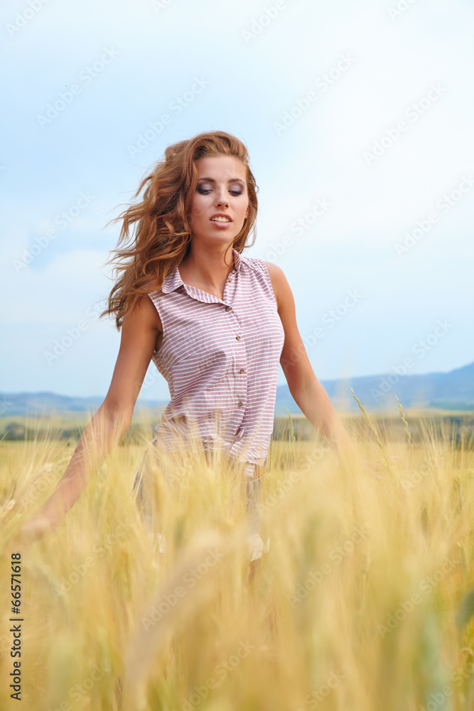 Happy woman in golden wheat