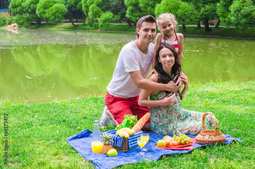 Happy cute family of three picnicking outdoor © travnikovstudio