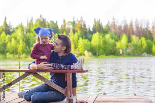 Young dad and little girl fishing on the lake