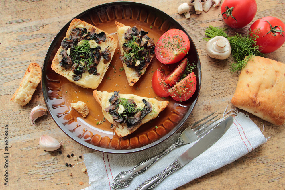 Plate with bruschettas with mushrooms, cheese, garlic and tomato Plate with bruschettas with mushrooms, cheese, garlic and tomato