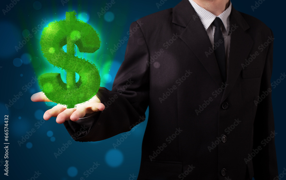 Young businessman presenting green glowing dollar sign Young businessman presenting green glowing dollar sign