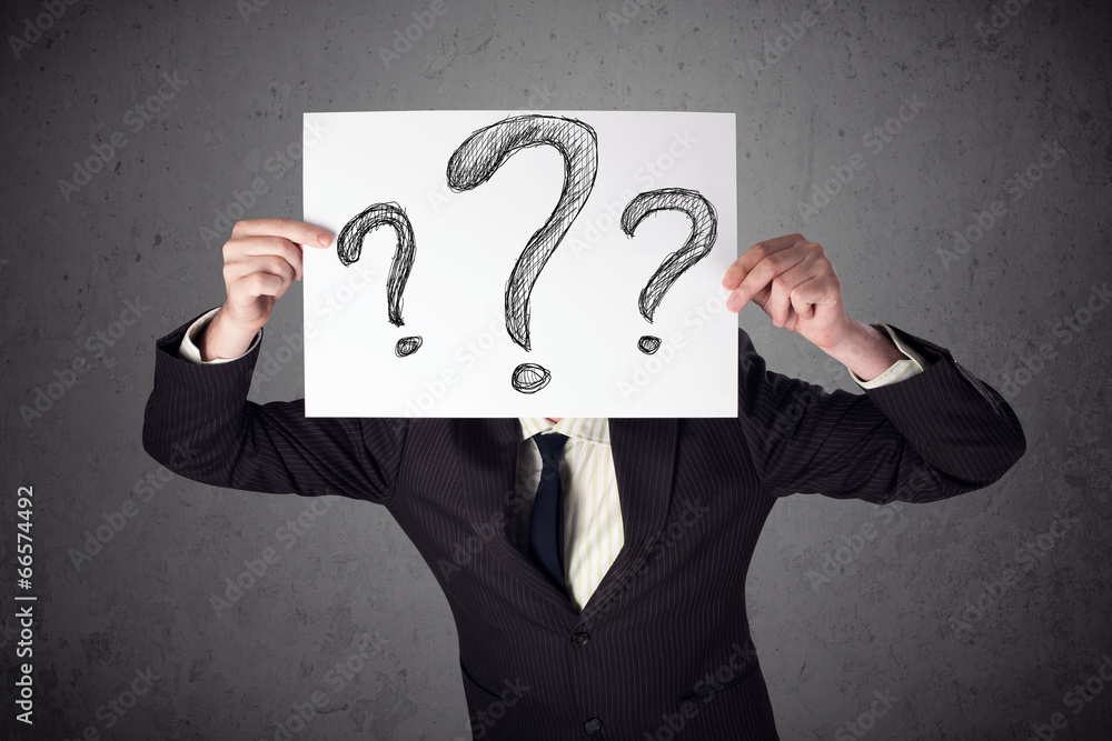 Businessman holding a paper with question marks in front of his Businessman holding a paper with question marks in front of his