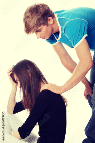 Troubled young girl comforted by her boyfriend