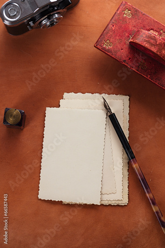 Obraz na plátne vintage red leather ink blotter  with retro post cards on leathe