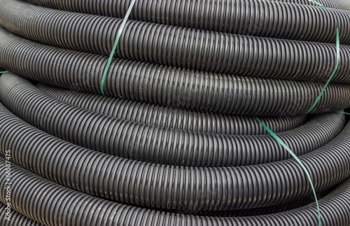 Roll of black flexible conduit nylon pipe background
