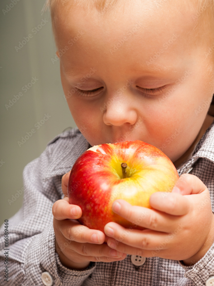 Little boy child kid eating apple fruit at home Little boy child kid eating apple fruit at home