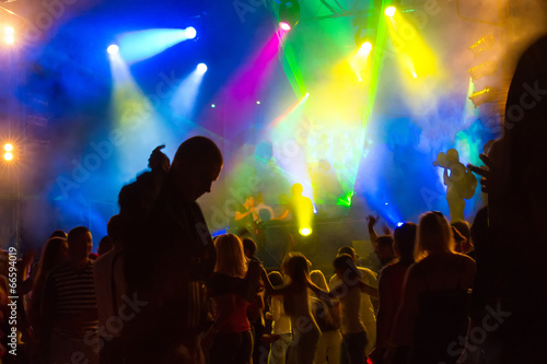Dancing People in a Nightclub and Concert Lighting.