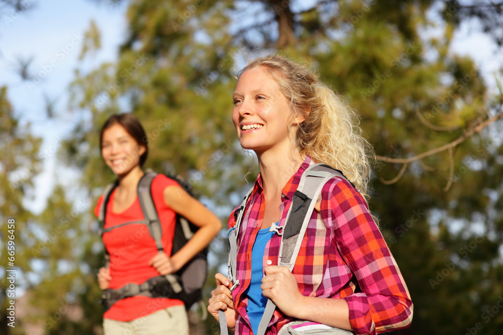 Active women - hiking girls walking in forest Active women - hiking girls walking in forest