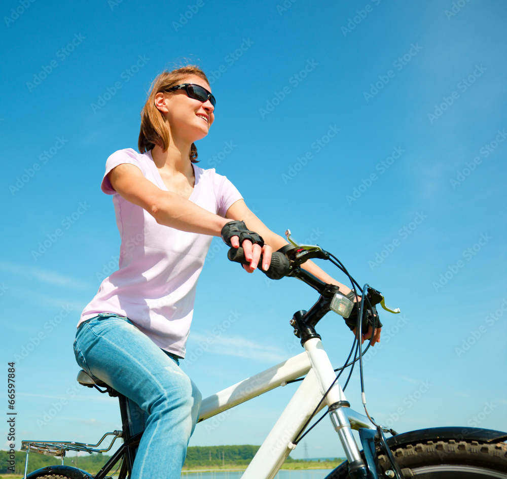 Young woman is sitting on her bicycle Young woman is sitting on her bicycle