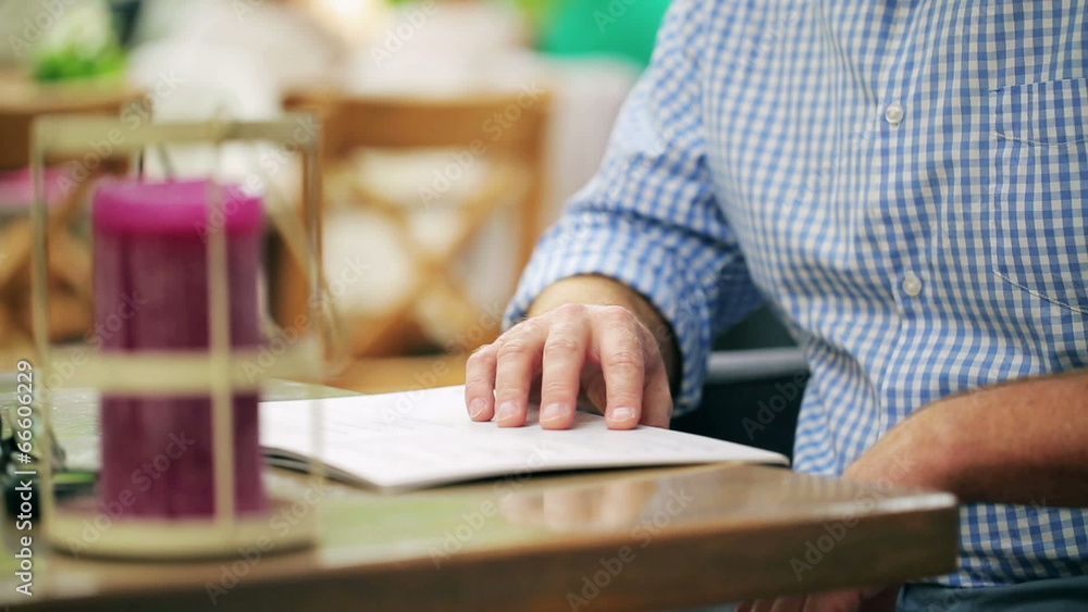 Man choosing meal from menu in restaurant, steadycam shot