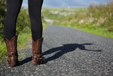 Female in brown boots standing on road