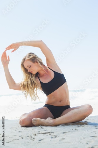 Fit blonde sitting in yoga pose on the beach © WavebreakmediaMicro