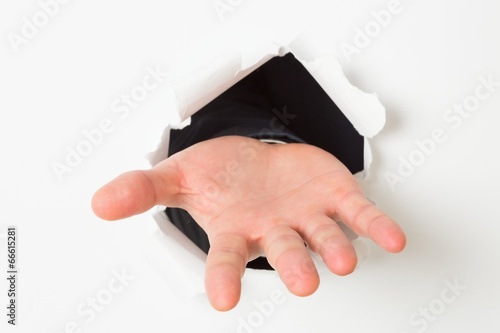Quadro em tela Open hand bursting through paper