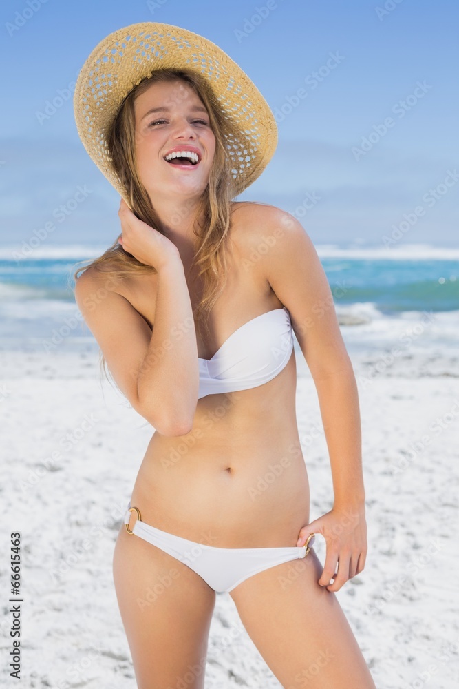 Beautiful laughing blonde on the beach in white bikini and sunha