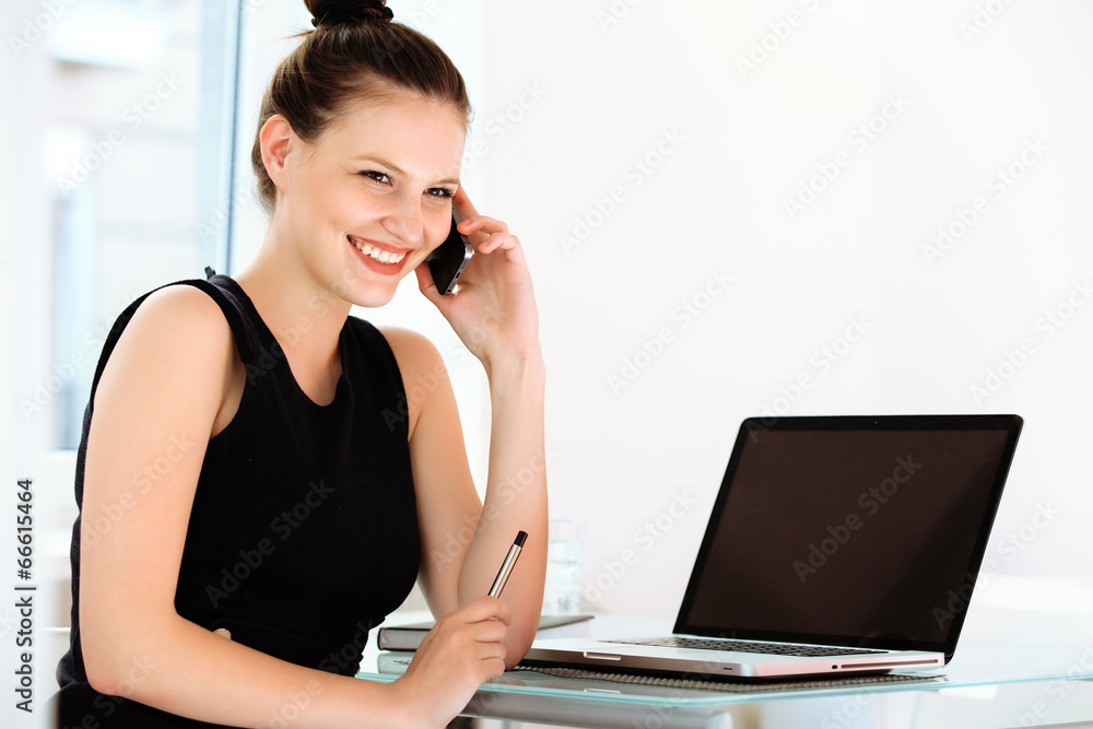 Businesswoman talking on mobile phone in a office Businesswoman talking on mobile phone in a office