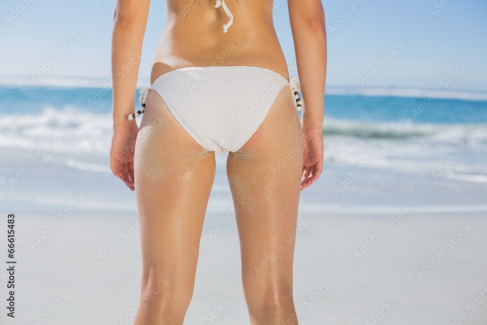 Rear view of fit woman in white bikini on beach Rear view of fit woman in white bikini on beach