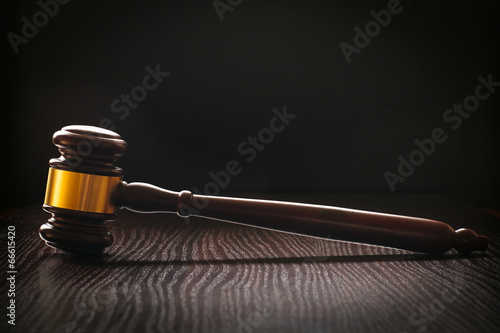 фотографія Wooden gavel on a textured dark wood surface