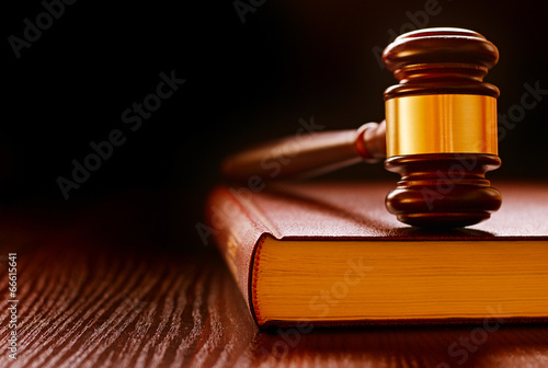 Wood and brass judges gavel on a law book photo