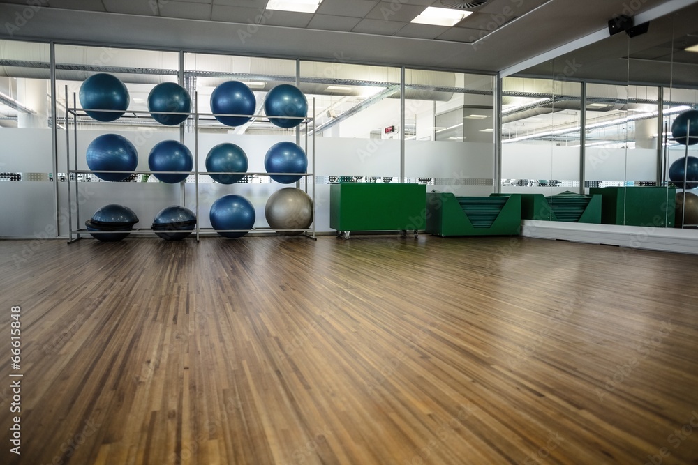 Large empty fitness studio with shelf of exercise balls Large empty fitness studio with shelf of exercise balls
