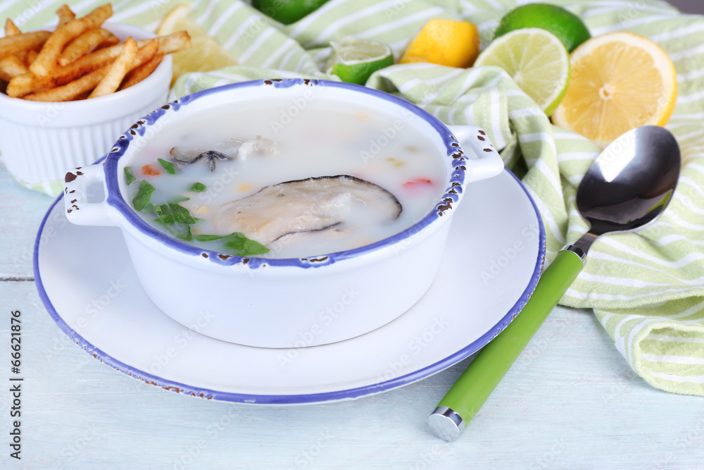 Tasty soup with oysters on wooden table