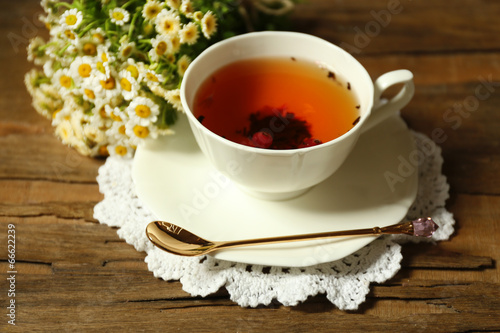 Cup of fresh herbal tea on wooden table
