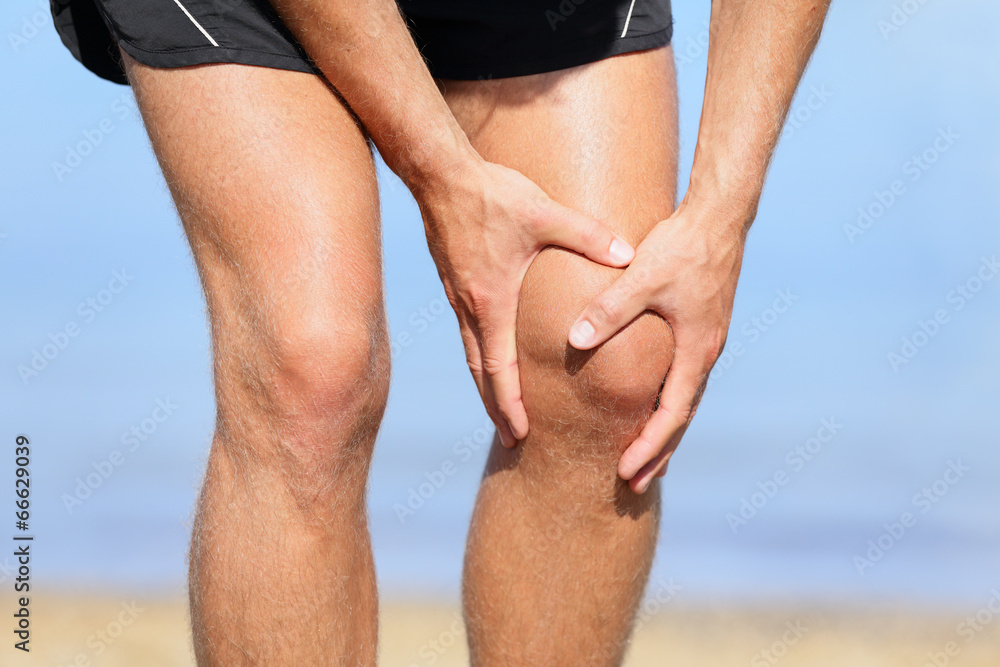 Runner injury - Man running with knee pain Runner injury - Man running with knee pain