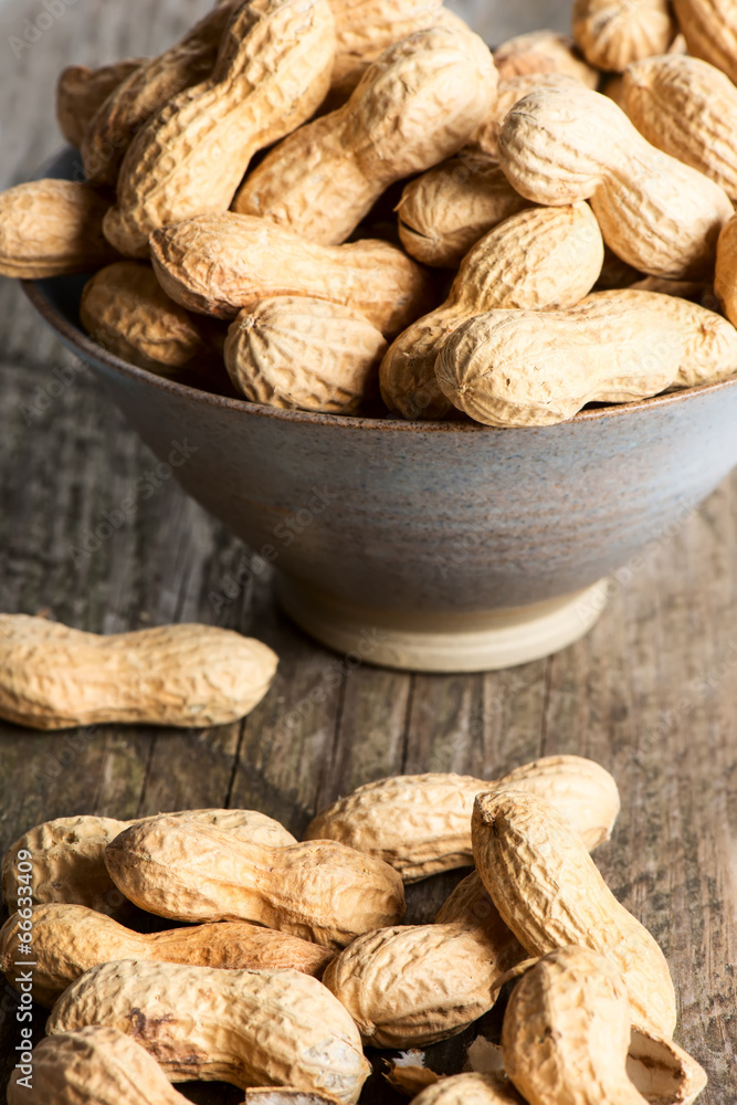 Peanuts in shell on wooden table in bowl Peanuts in shell on wooden table in bowl