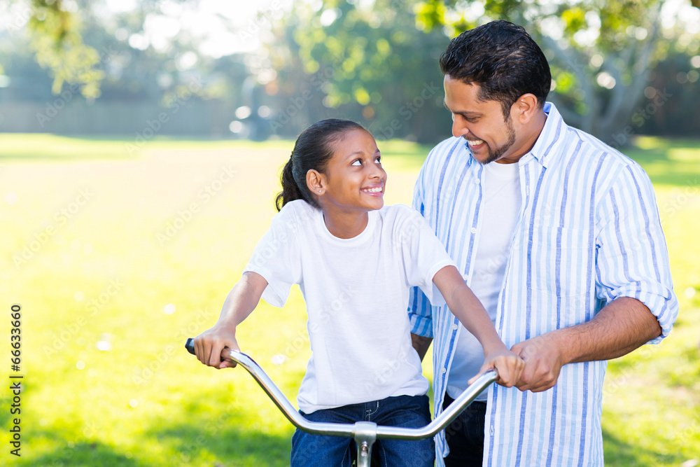 Obraz premium indian father teaching daughter to ride a bicycle