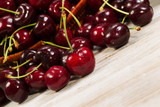 Angled view of Ripe Black Cherries laying in front of basket on