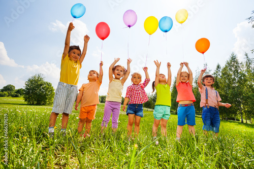 canvas print motiv - Sergey Novikov : Happy kids with balloons and arms up in the sky