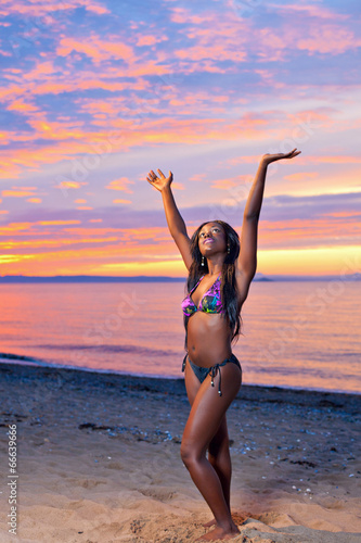 Beautiful black African American woman posing on the beach at su