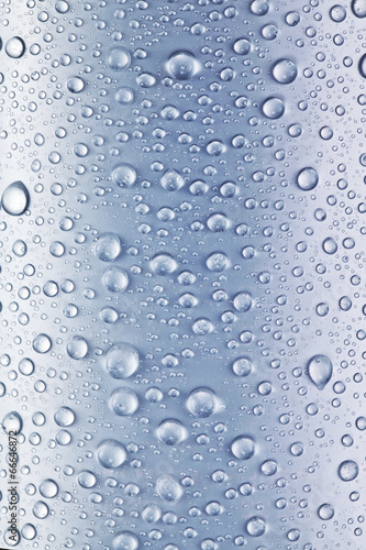 Water drops over blue glass background.