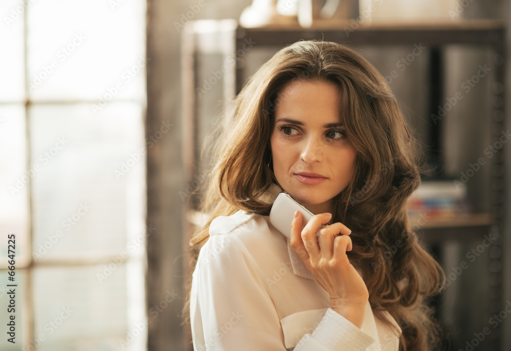 Fototapeta premium Portrait of thoughtful young woman with cell phone 