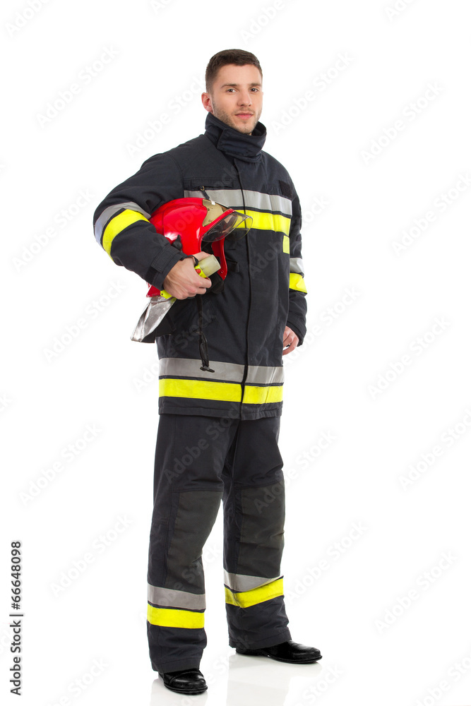 Firefighter posing with helmet under his arm Firefighter posing with helmet under his arm