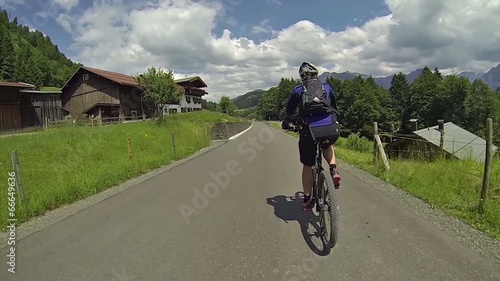 Female biker riding on a mountain valley street