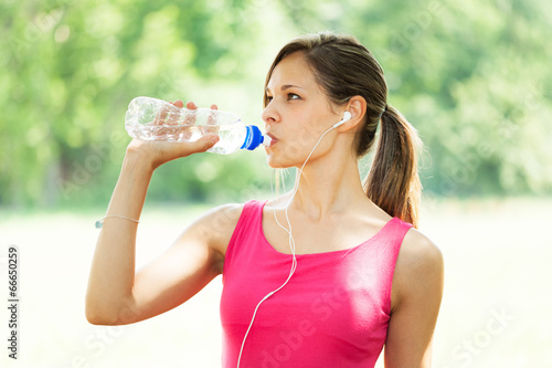 Active woman drinking water