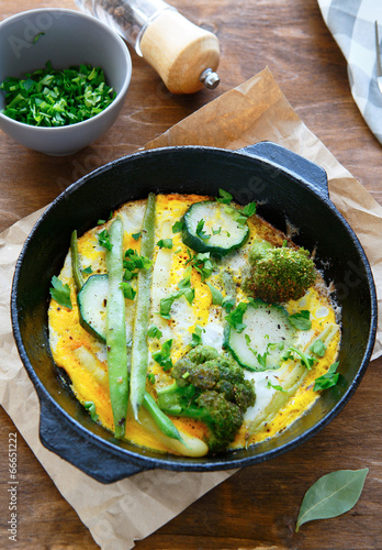 omelette with zucchini and green beans in a pan