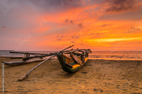 Fényképezés Traditionelles Auslegerboot bei Sonnenuntergang am Strand