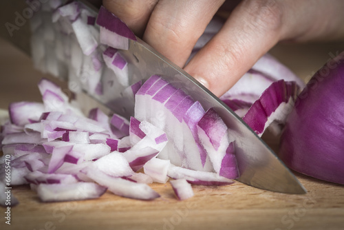 Cortando cebolla con un cuchillo en la cocina sobre la tabla