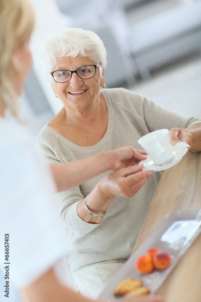 Homecarer giving tea to elderly woman Homecarer giving tea to elderly woman
