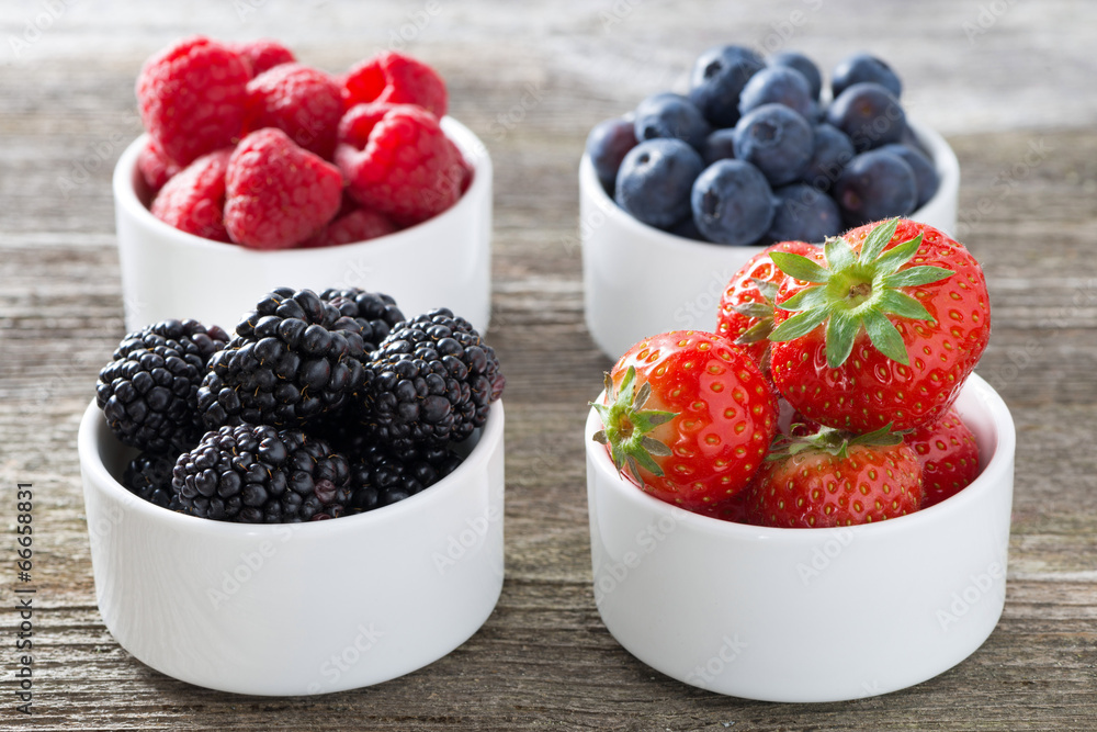 strawberries, blackberries, raspberries and blueberries in bowls