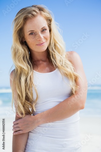 Gorgeous blonde smiling at camera on the beach