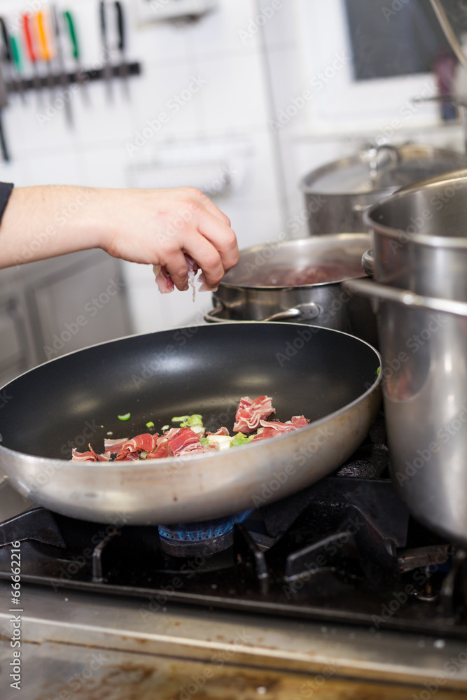 Chef or braising meat in a frying pan Chef or braising meat in a frying pan