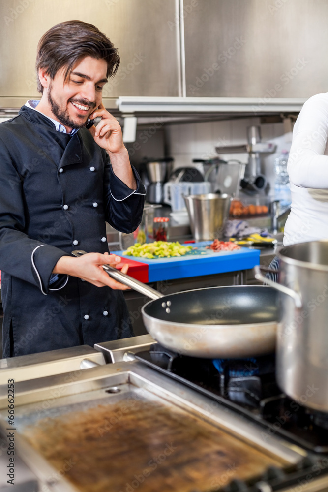 Chef taking a call on his smartphone Chef taking a call on his smartphone