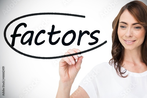 Businesswoman writing the word factors